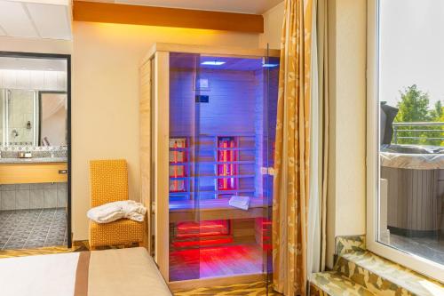 赫维兹莲花温泉酒店的一间设有床铺的客房内的玻璃淋浴间