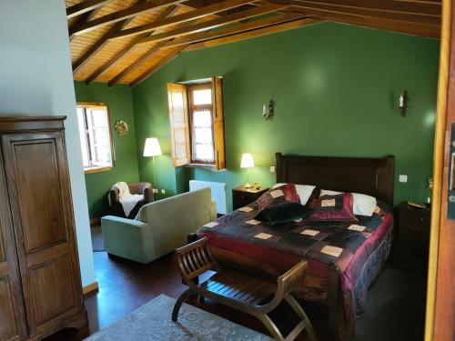 圣玛丽亚大德费拉Quinta Padre Lobo的一间卧室设有绿色的墙壁、一张床和椅子