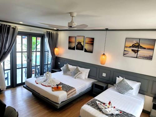 琅勃拉邦LuangPrabang Pearl Hotel的一间带两张床的卧室和一个阳台