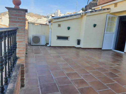 阿达莱斯Dúplex Caminito de Ardales的拥有砖地板和白色建筑的阳台
