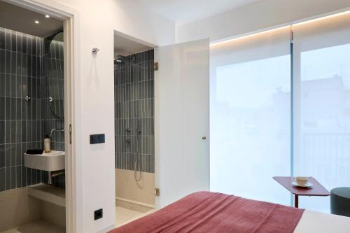 比雷埃夫斯Twinn Downtown Piraeus的一间卧室配有一张床、淋浴和盥洗盆