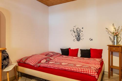 特里贝格Schwarzwald Nescht Triberg的一间卧室配有红色枕头的床