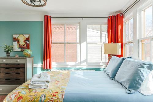 斯汤顿The Shenandoah Suite的一间卧室配有一张蓝色墙壁和窗户的床