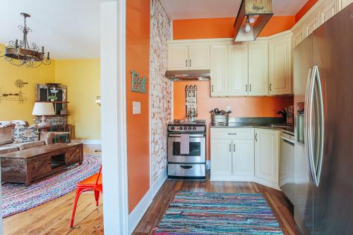 斯汤顿The Shenandoah Suite的厨房配有白色橱柜和橙色墙壁