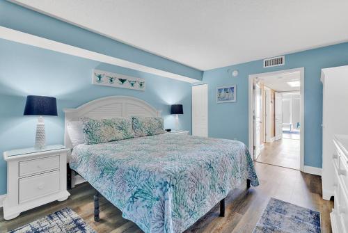 默特尔比奇Bay Watch Resort 1203 - Perfect Oceanside Getaway的一间卧室设有一张床和蓝色的墙壁