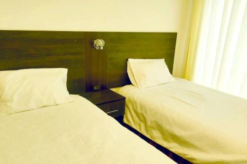 安达韦拉斯Apartamento Andahuaylas的卧室内两张并排的床