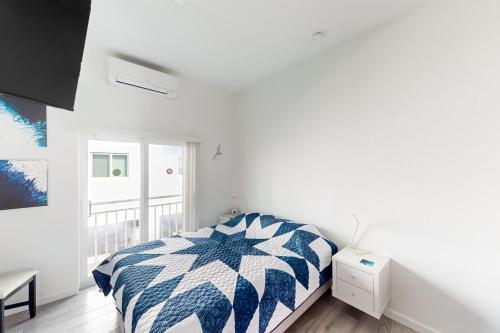 马拉松Ocean Isles 50的一间卧室配有一张带蓝色和白色棉被的床