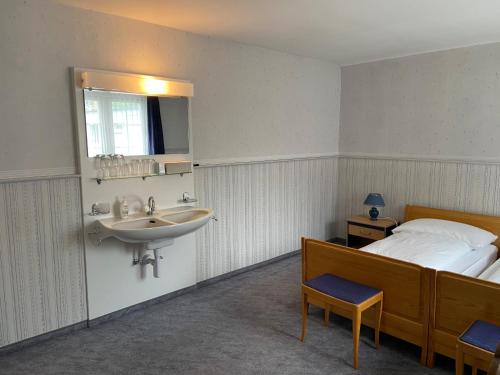 WattwilHotel National的卧室配有水槽、床和镜子
