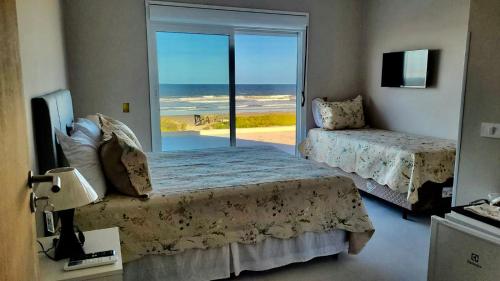 瓜拉图巴Pousada Recanto Vô Fredo的一间带两张床的卧室,享有海景