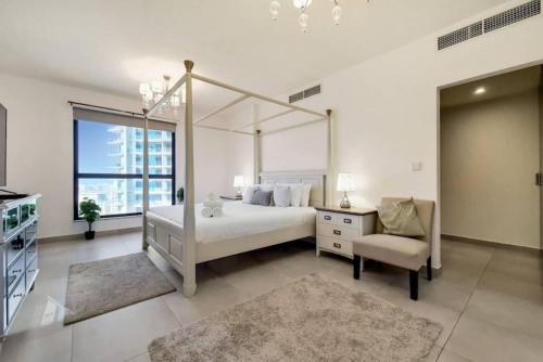 迪拜Jbr Sea View Captivating 4-Bed Apartment in Dubai的白色卧室配有天蓬床和椅子