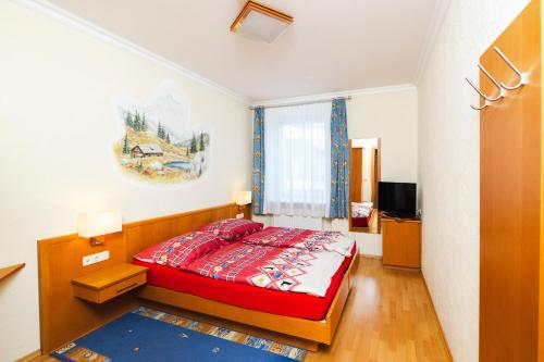 PredlitzFerien beim Steiner的一间在房间内配有红色床的卧室