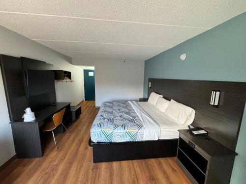 东叙拉古Motel 6 East Syracuse, NY - Airport的配有一张床和一张书桌的酒店客房