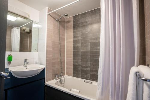 曼彻斯特钟摆酒店 的一间带水槽、浴缸和淋浴的浴室