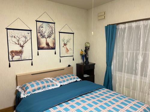 富良野PENSION YunShuiYao雲水瑶民宿的卧室配有一张床,墙上挂着鹿的照片