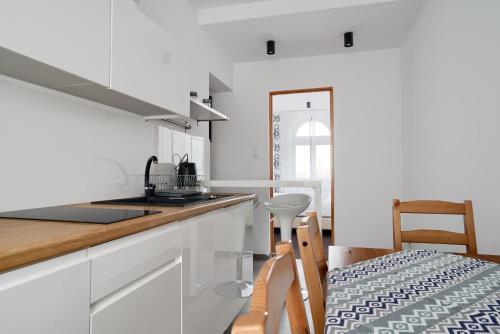 海乌姆诺APARTAMENT PRZY RYNKU II的厨房配有白色橱柜和台面