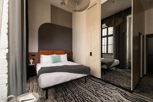 布达佩斯Hotel GIN Budapest的一间卧室配有一张床和一面大镜子