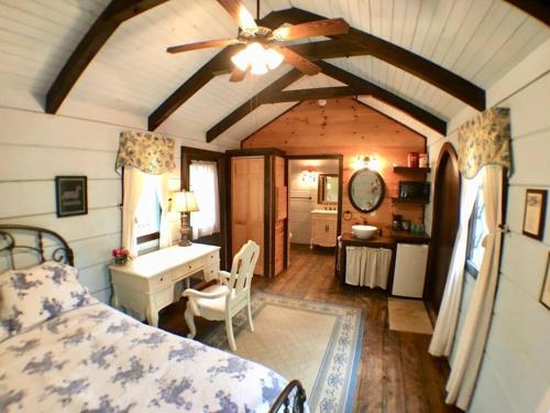 赛维尔维尔Tiny Home Cottage Near the Smokies #7 Tilly的一间卧室配有一张床、一张桌子和吊扇