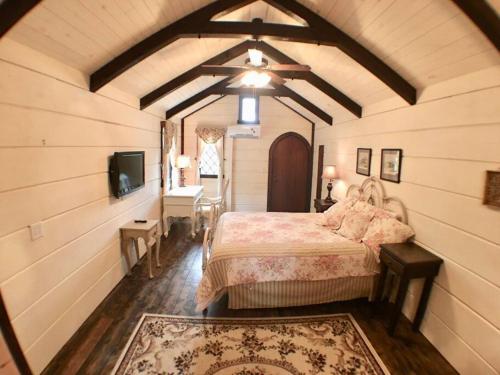 赛维尔维尔Tiny Home Cottage Near the Smokies #8 Helga的一间卧室配有一张床,并在一间客房内配有电视。