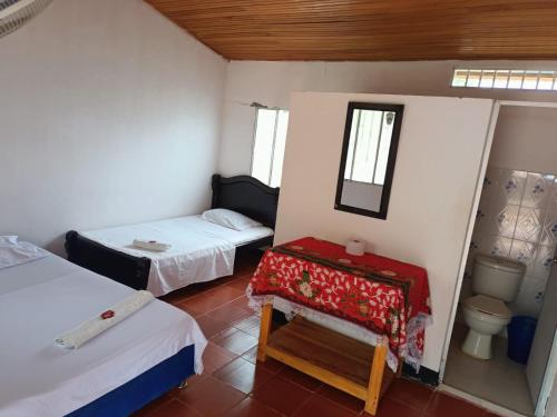 比利亚维哈Hostal Sol de Verano Doña Lilia的小房间设有两张床和卫生间