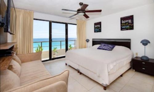坎昆Perfect vacation getaway,Ocean View,Wifi, Beach的一间卧室设有一张床和一个海景阳台