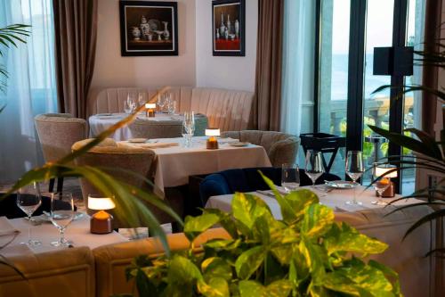 卡斯卡伊斯格兰瑞沃伊塔里Spa酒店的餐厅设有白色的桌椅和窗户。