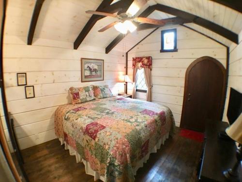 赛维尔维尔Tiny Home Cottage Near the Smokies #9 Frieda的一间卧室配有一张床和吊扇
