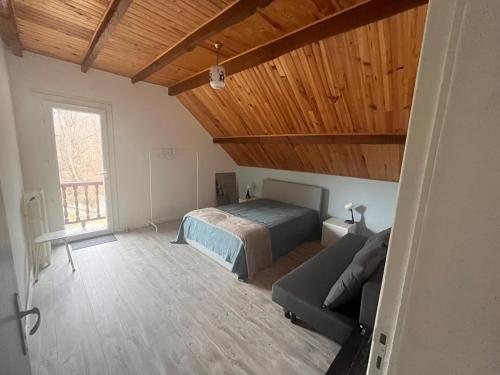 阿克斯莱泰尔姆Chalet d’Ax Pyrénées的一间卧室配有一张床和一张沙发