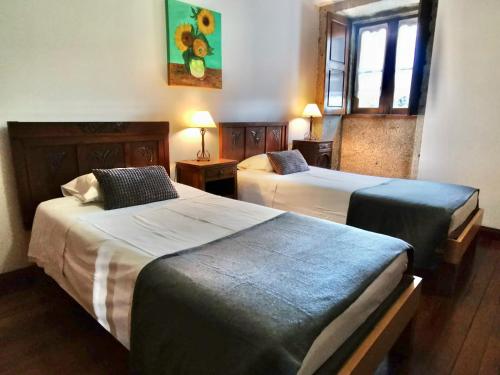 布拉加Casa do Faial - Braga的酒店客房设有两张床和窗户。