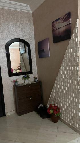 梅克内斯appartement familiale的浴室的墙上设有镜子和梳妆台