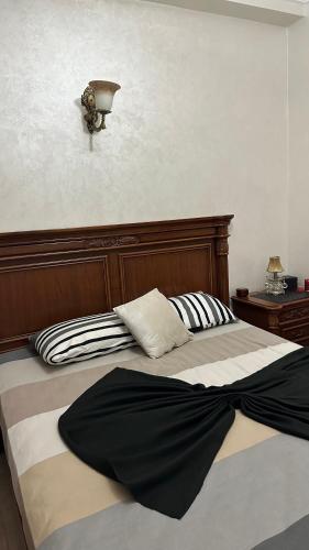 梅克内斯appartement familiale的一张带木制床头板和枕头的床