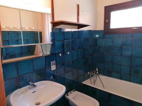 大博尔南Appartement Le Grand-Bornand, 1 pièce, 5 personnes - FR-1-241-202的蓝色瓷砖浴室设有水槽和浴缸
