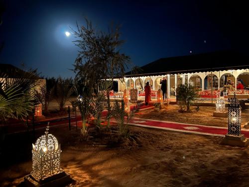 梅尔祖卡Sahara Majestic Luxury Camp的夜间在院子里灯火通明的建筑物