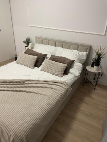 华沙AirPort Apartment的一张配有白色床单和枕头的大床