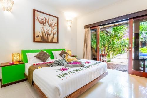 吉利阿尔Senang Luxury Villa的一间卧室配有一张大床和绿色床头板