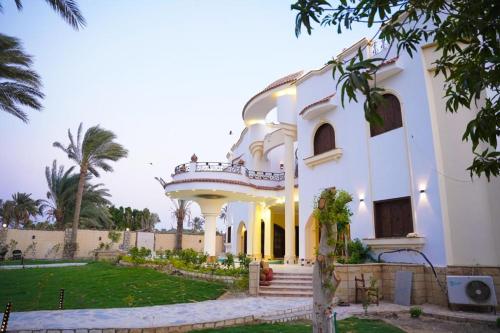 法尤姆Tunis Beach Families Only的一座大型白色建筑,设有阳台和庭院