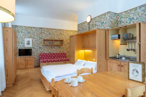 卡雷扎湖Grand Hotel Carezza Multiproprietà的酒店客房配有一张床铺和一张桌子。