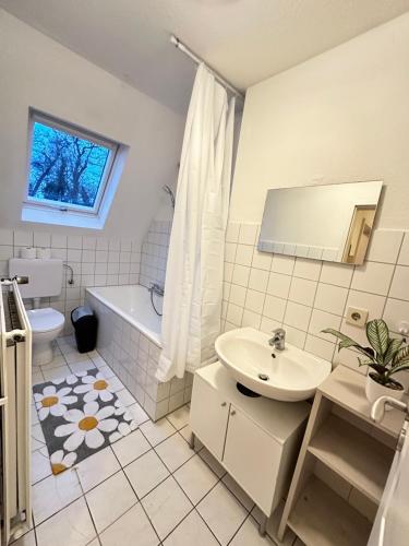 居特斯洛Modern Apartment in Gütersloh Avenwedde的一间带水槽、浴缸和卫生间的浴室
