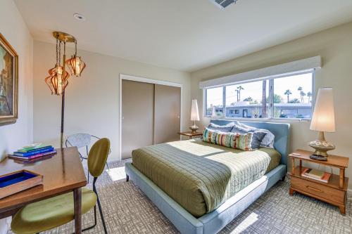 棕榈泉Luxe Palm Springs Home - Close to Downtown!的一间卧室配有一张床、一张书桌和一个窗户。
