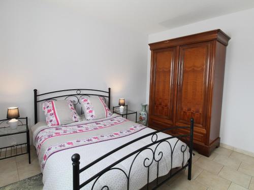 La ViardièreGîte Lys-Haut-Layon, 2 pièces, 2 personnes - FR-1-622-21的一间卧室配有一张床和一个木制橱柜
