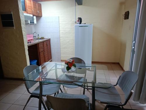 特玛斯德戴曼Los Lirios de Dayman的厨房配有玻璃桌、椅子和冰箱