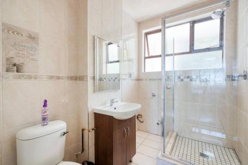 德班Lovely 2-bedroom apartment, with an amazing view的浴室配有卫生间、盥洗盆和淋浴。