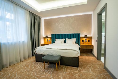 蒂米什瓦拉ATLAS Hotel的酒店客房带一张大床和一把椅子