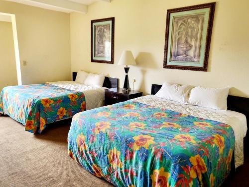 杰克逊维尔Metro Inn & Suites的酒店客房,配有两张带彩色床单的床