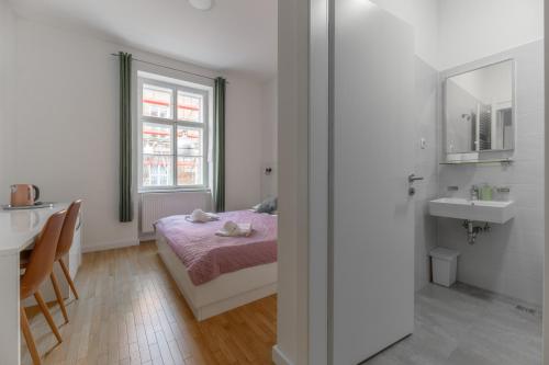 萨格勒布Niva Rooms & Studio Apartment的一间卧室配有床、水槽和镜子
