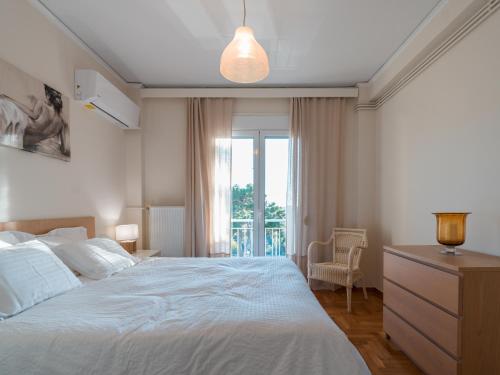 雅典Marousi Cozy Apartment的卧室设有一张白色大床和一扇窗户。
