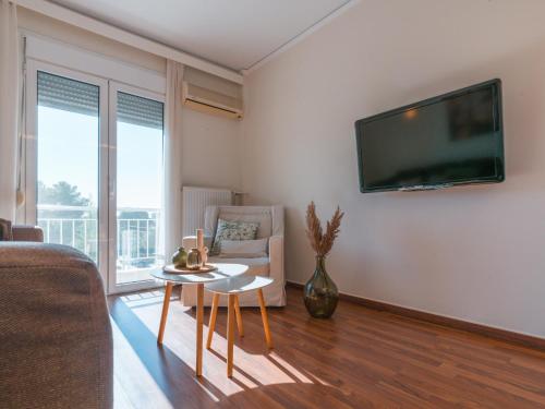 雅典Marousi Cozy Apartment的客厅配有沙发和墙上的电视