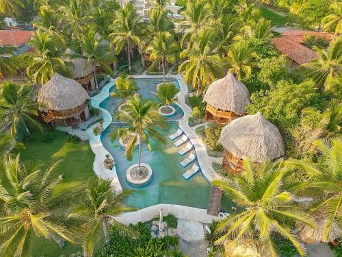 La Herradura太阳海岸托尔图加村酒店的享有棕榈树度假村游泳池的空中景致