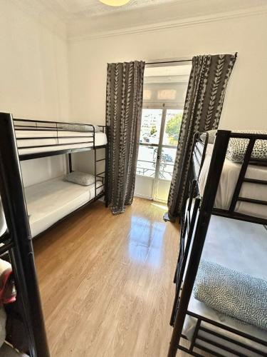 里斯本Samps Hostel的客房设有两张双层床和一扇窗户。