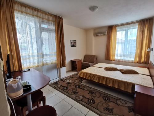 拉夫达Guest House Georgieva Ravda的卧室配有一张床、一张书桌和窗户。