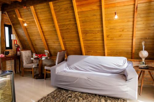 皮萨拉斯Chalé Sunset的客厅设有白色沙发和木墙